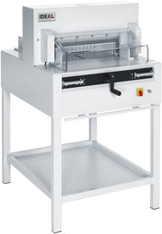 A white IDEAL 4850 electric guillotine with a transparent safety guard and a hand crank, designed for paper folding and cutting.