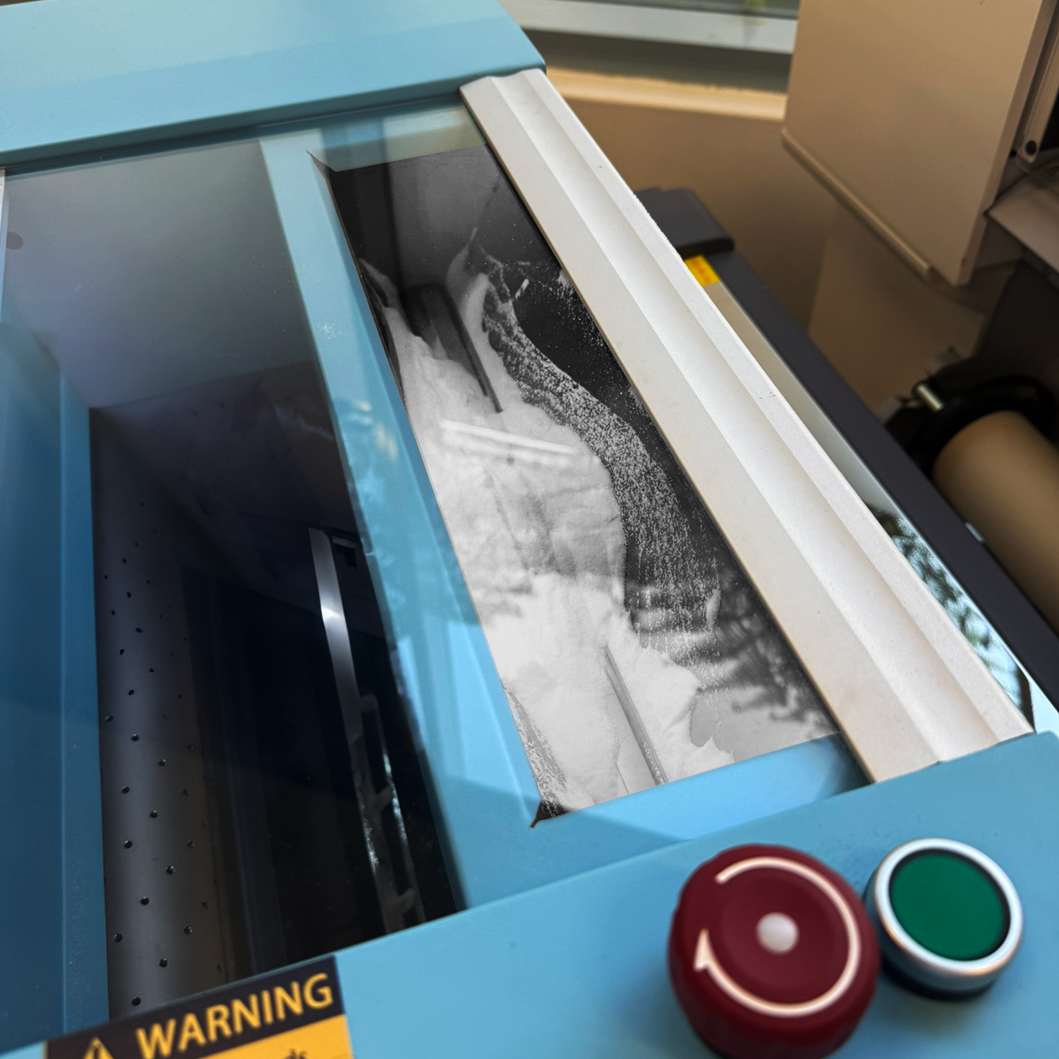 Laser cutting machine with a piece of material being cut, showing a close-up of the cutting process.