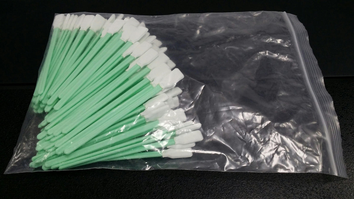 A pack of foam cleaning swabs with green and white tips, sealed in a plastic bag.